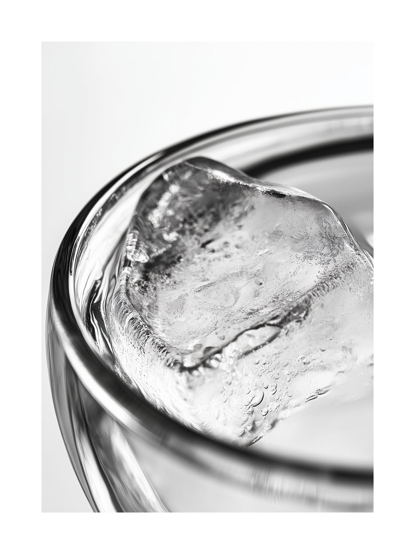 Close-up black and white photo of an ice cube in a clear glass