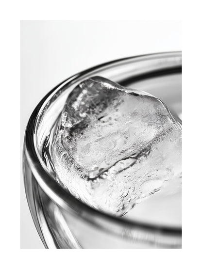 Close-up black and white photo of an ice cube in a clear glass