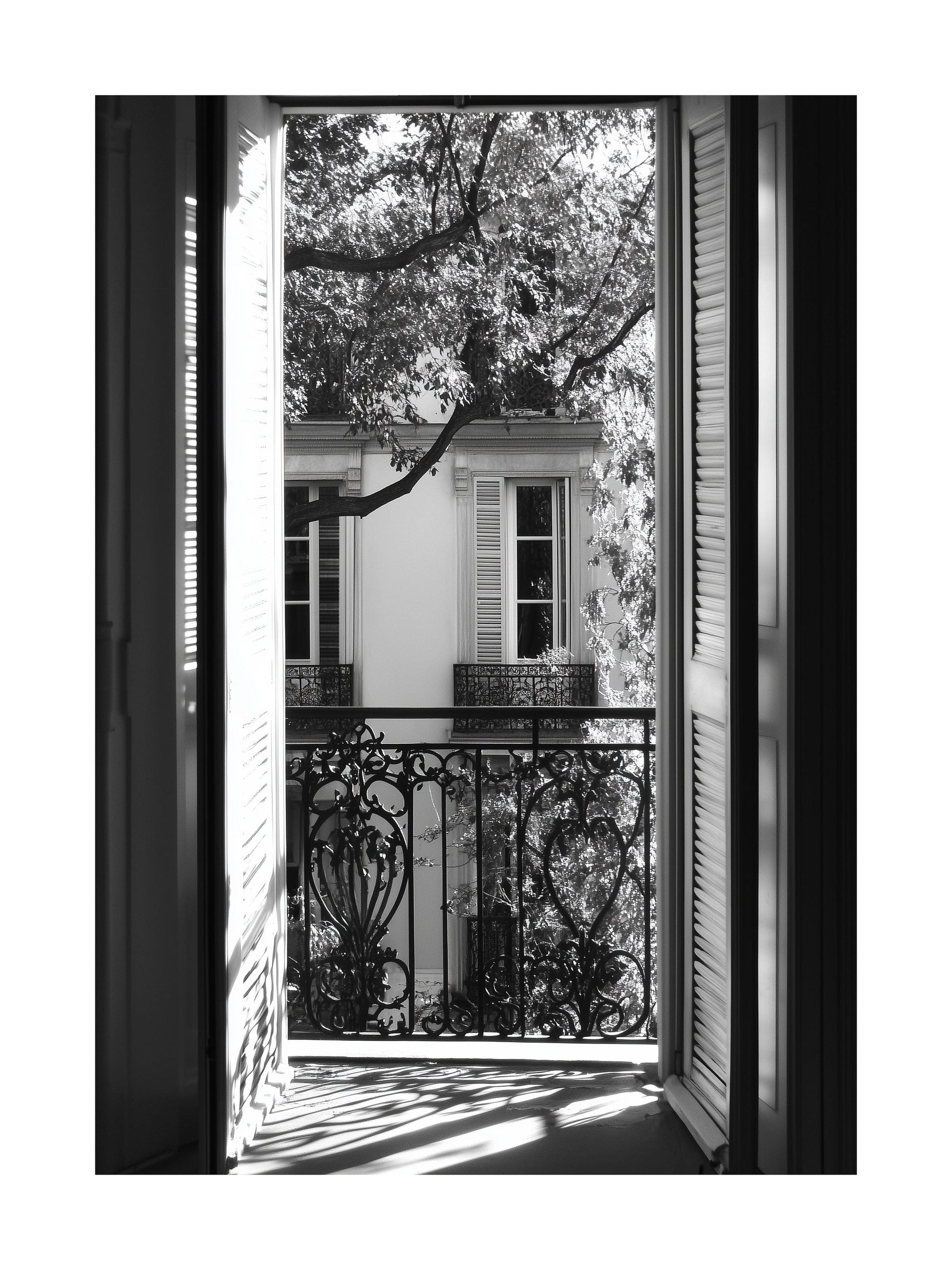 Black and white photo of view through open balcony doors in Paris