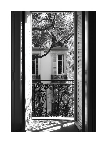 Black and white photo of view through open balcony doors in Paris