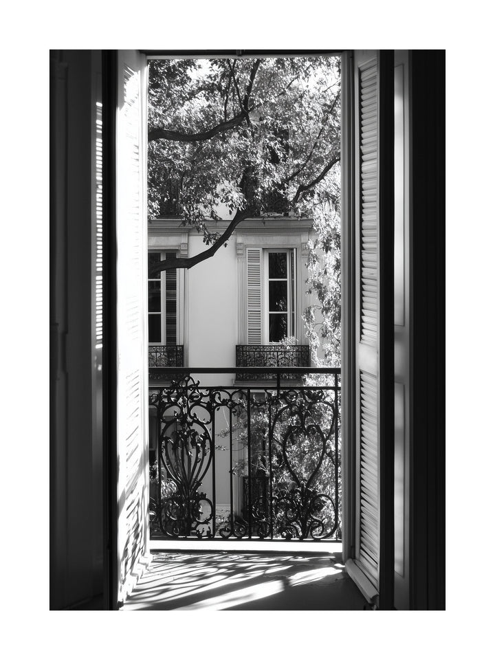 Black and white photo of view through open balcony doors in Paris