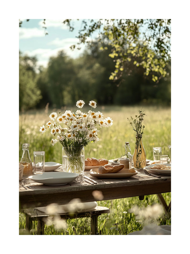Rustic picnic table in a sunny Swedish meadow with daisies and glassware