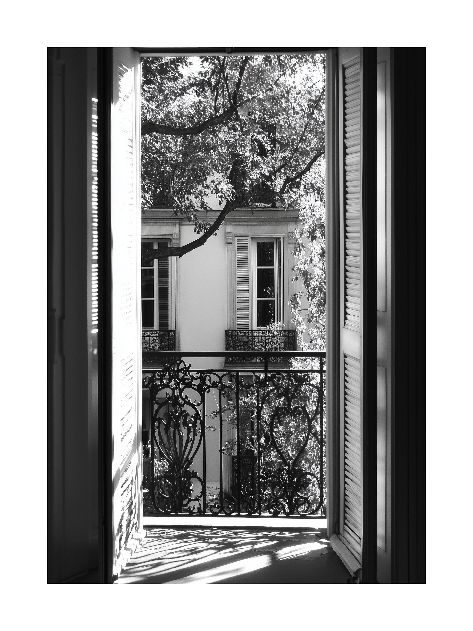 Black and white photo of view through open balcony doors in Paris