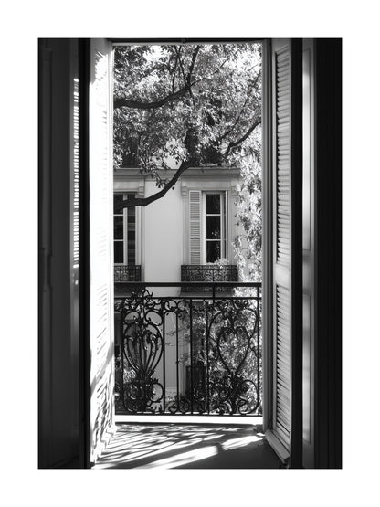 Black and white photo of view through open balcony doors in Paris