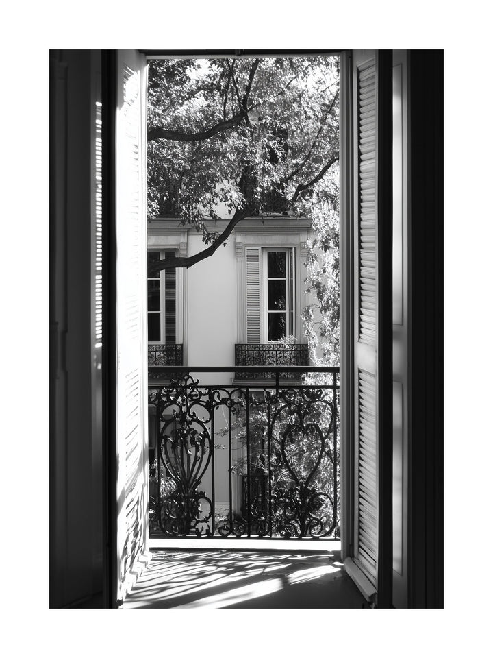 Black and white photo of view through open balcony doors in Paris