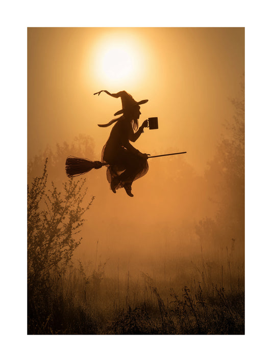 Halloween poster of witch flying on broomstick holding coffee mug in golden sunrise