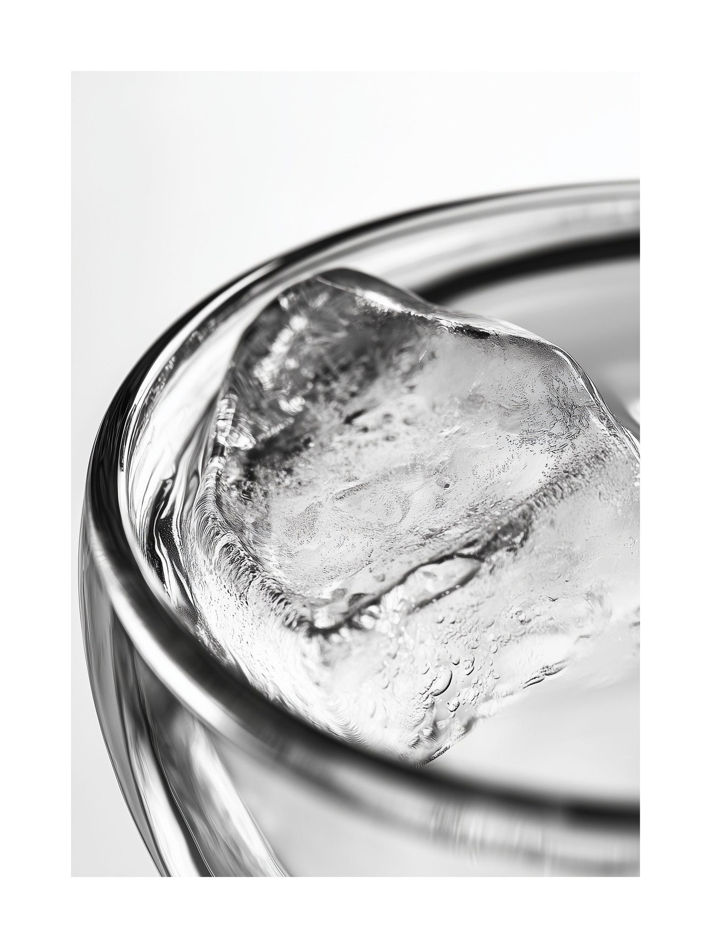 Close-up black and white photo of an ice cube in a clear glass