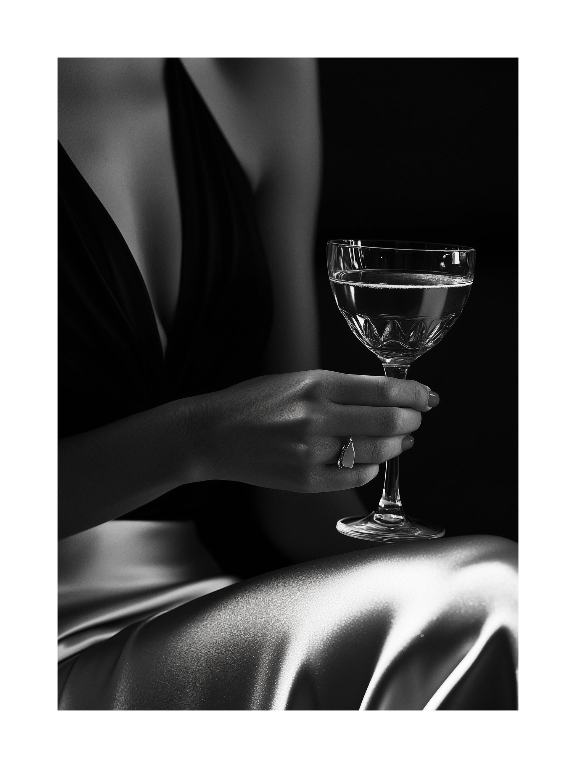 Black and white photo of a woman's hand holding a champagne glass