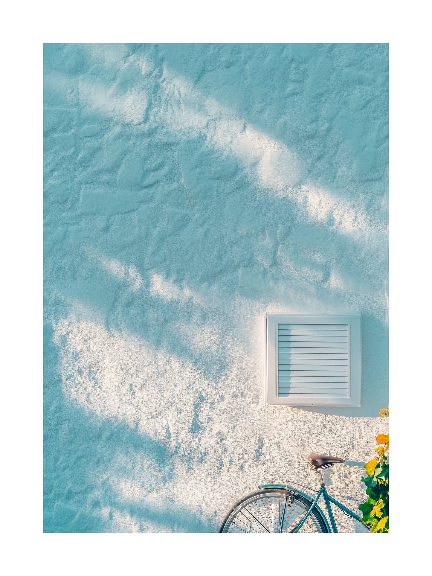 Light blue wall with shadows and a bicycle in a coastal Mediterranean town. Ideal for wall art in your home, office, or studio.