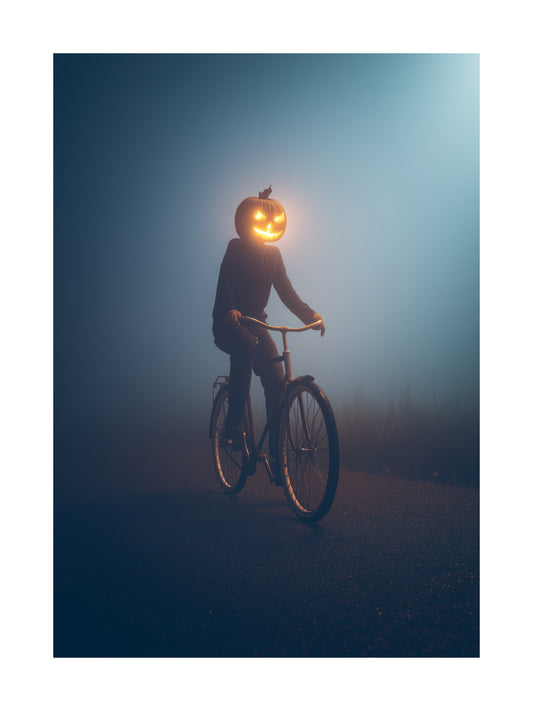 Poster of a pumpkin-headed figure riding a bicycle in the fog