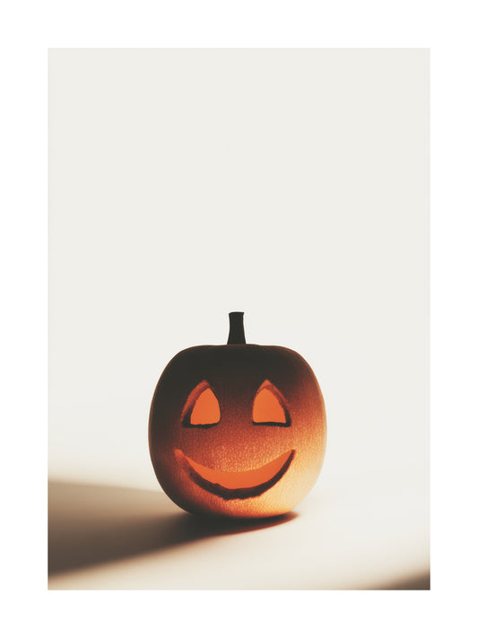 Minimalist smiling carved pumpkin glowing in warm light