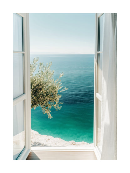 View from a balcony overlooking turquoise ocean waters and an olive tree. Ideal for wall art in your home, office, or studio.
