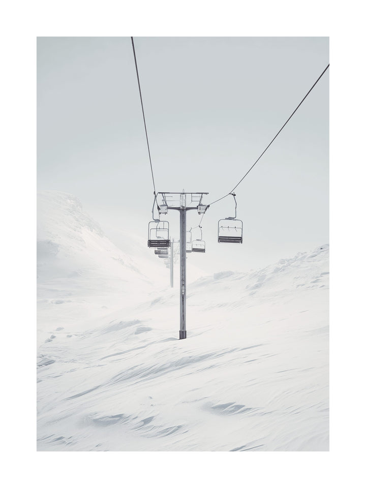Minimal photograph of a ski lift in a snowy white mountain landscape.